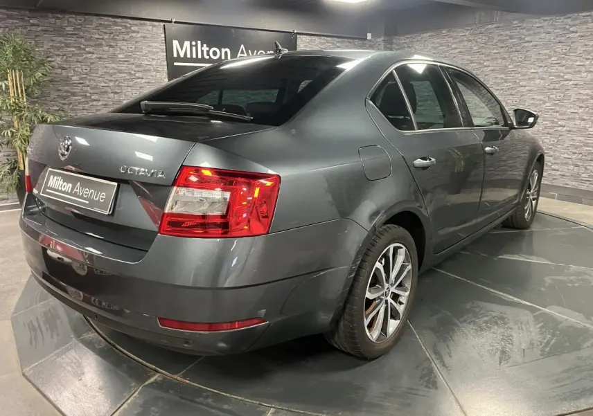 Vue 3/4 arrière droite d'une Skoda Octavia gris métallisé avec feux arrière LED et jantes alliage 17 pouces.