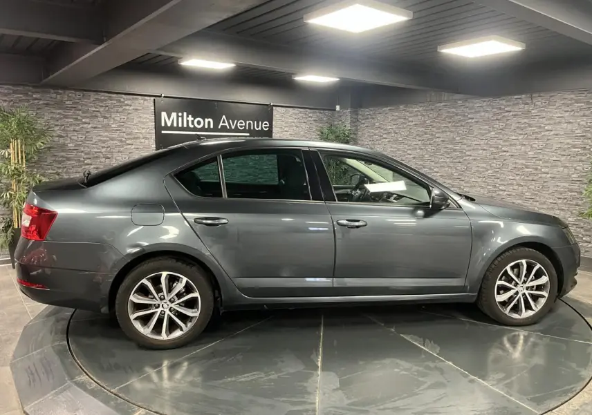 Profil côté gauche d'une Skoda Octavia gris métallisé 2020 avec jantes alliage et poignées couleur carrosserie.