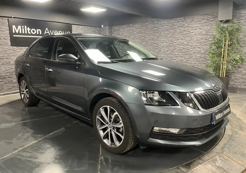 SKODA OCTAVIA gris métallisé vue 3/4 avant droit avec calandre noire et jantes alliage 17 pouces.