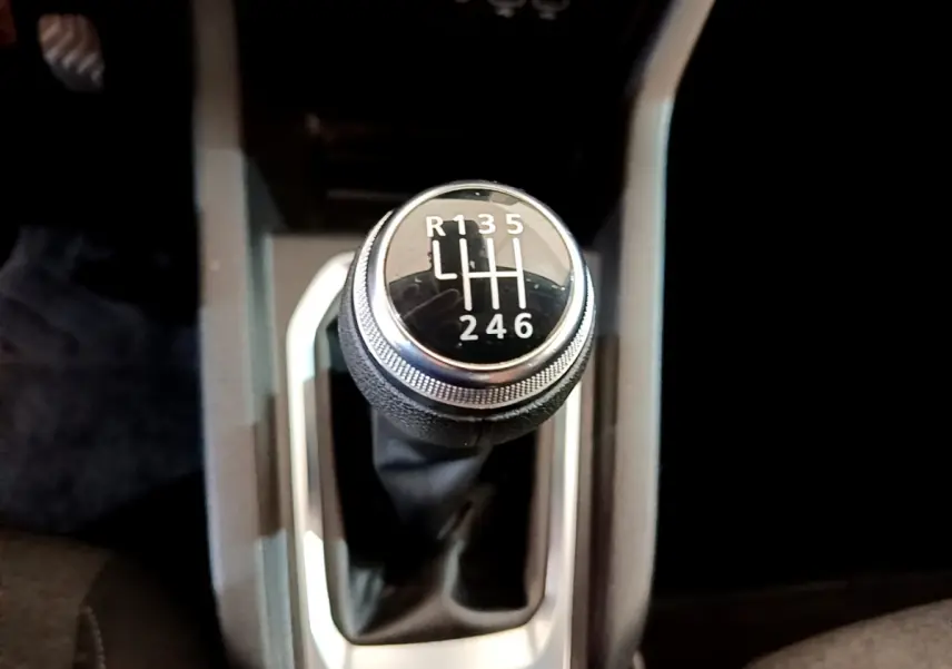 Le levier de vitesses manuel noir de la Renault Clio Business Blue dCi 85, vu de dessus, avec marquage des rapports blancs.