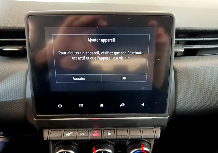 Écran tactile central affichant l'ajout d'appareil Bluetooth dans le tableau de bord noir d'une Renault Clio Business 2020.