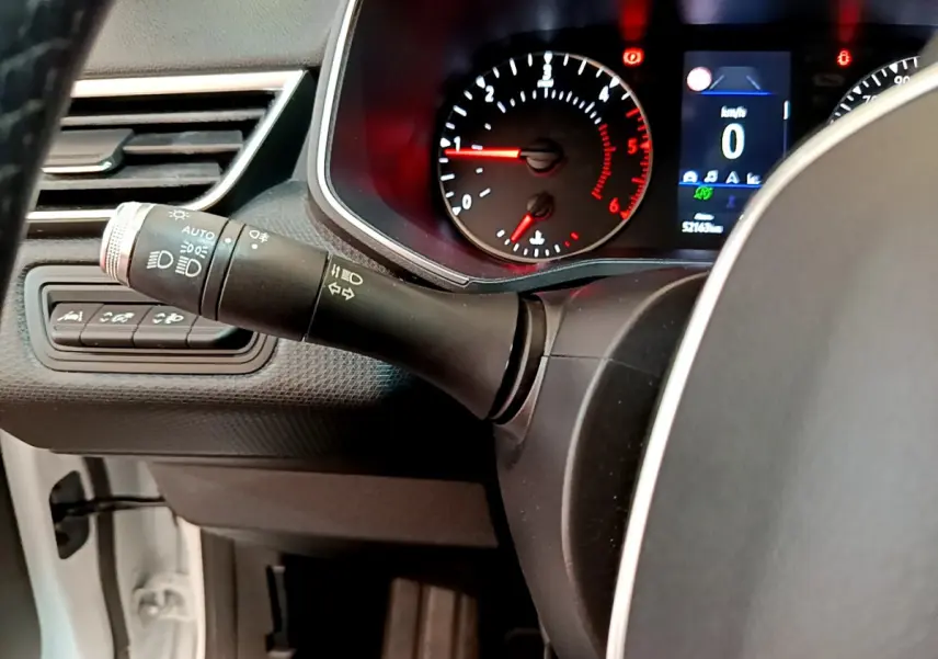 Gros plan sur le combiné d'instruments et la commande de phares d'une Renault Clio Business Blue dCi 85 blanche de 2020.