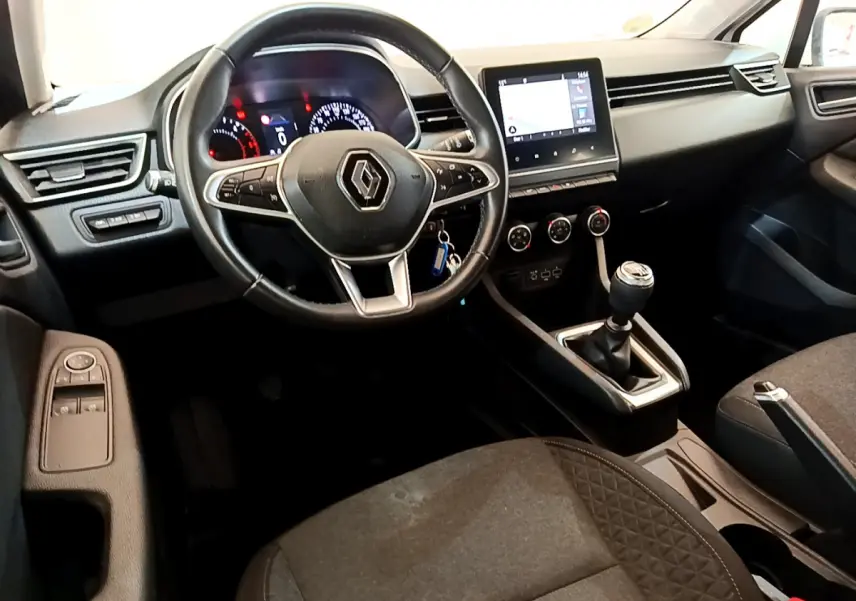 Intérieur de Renault Clio Business 2020, vue côté conducteur, volant cuir, écran tactile et boîte manuelle visibles.