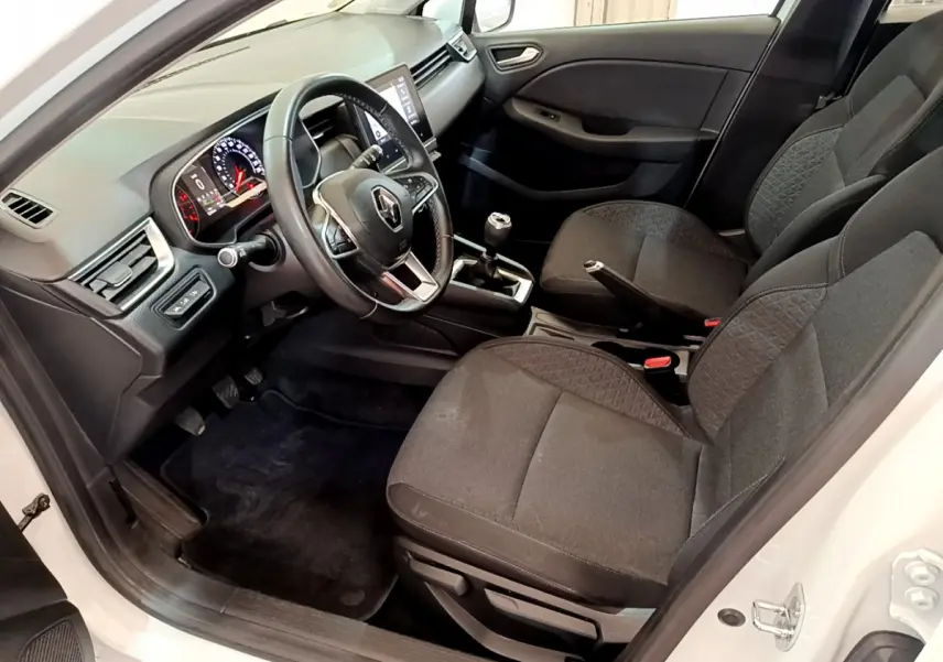 Intérieur côté conducteur d'une Renault Clio Business Blue dCi 85 blanche, avec tableau de bord numérique et volant multifonctions cuir.