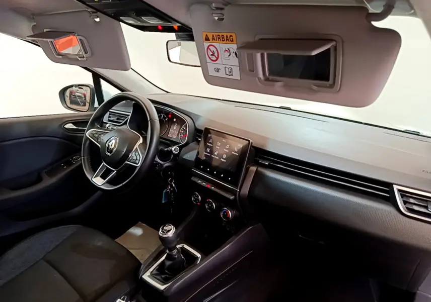 Intérieur avant droit de la Renault Clio Business Blue dCi 85 2020, volant cuir, écran tactile et boîte manuelle visibles.
