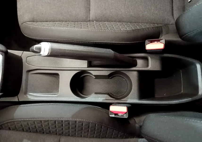 Vue plongeante sur la console centrale noire avec frein à main et porte-gobelets de la Renault Clio Business 2020.