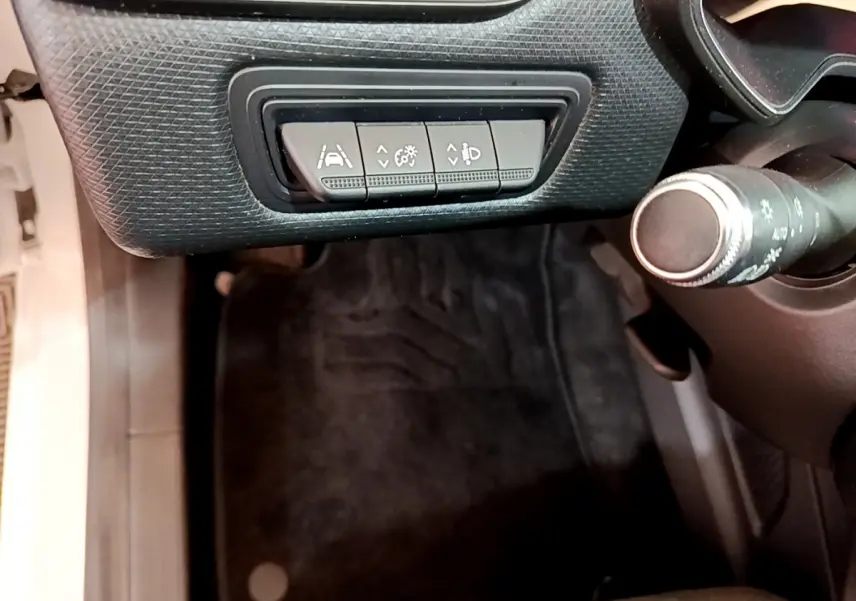 Vue intérieure rapprochée côté gauche du tableau de bord noir avec commandes d'assistance sur Renault Clio blanche 2020.