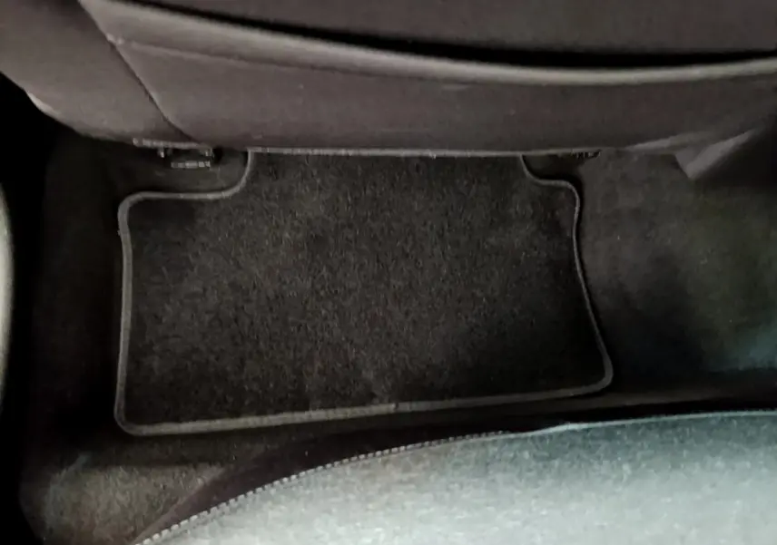 Vue rapprochée du tapis de sol noir côté passager arrière d'une Renault Clio Business Blue dCi 85 blanche de 2020.