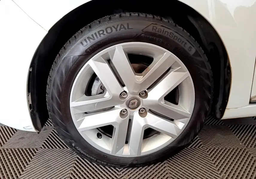 Gros plan sur la roue avant droite blanche d'une Renault Clio Business Blue dCi 85 avec jante alliage et pneu Uniroyal.