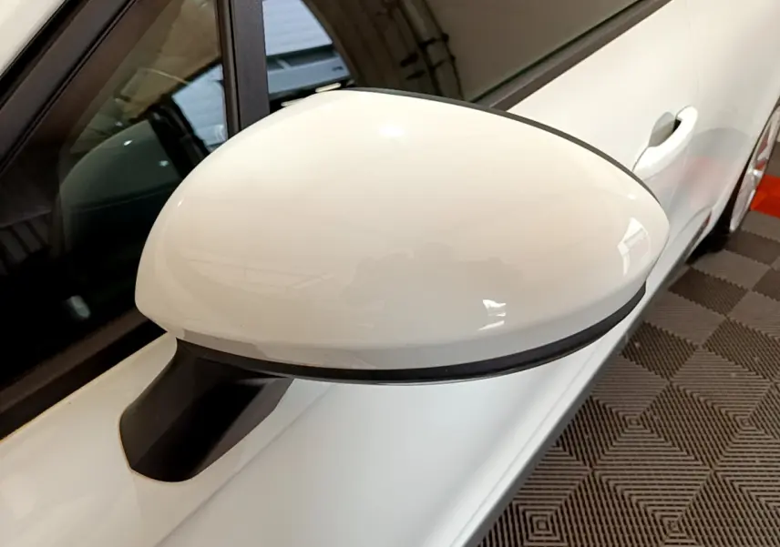 Rétroviseur blanc côté gauche d'une Renault Clio Business 2020 vue en gros plan sur fond intérieur.