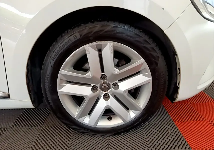 Gros plan sur la roue avant gauche blanche d'une Renault Clio Business Blue dCi 85 avec jante alliage distinctive.