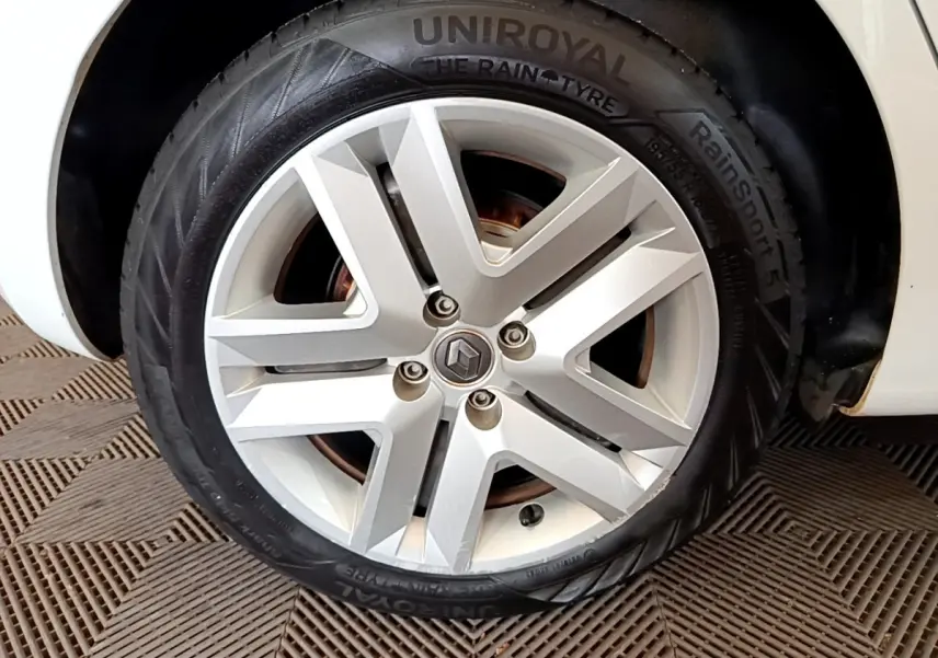 Gros plan sur la roue avant droite blanche d'une Renault Clio Business Blue dCi 85 avec jante alliage moderne.