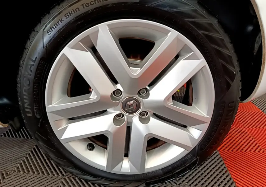 Gros plan sur la roue avant droite blanche d'une Renault Clio Business Blue dCi 85 avec jante alliage moderne.