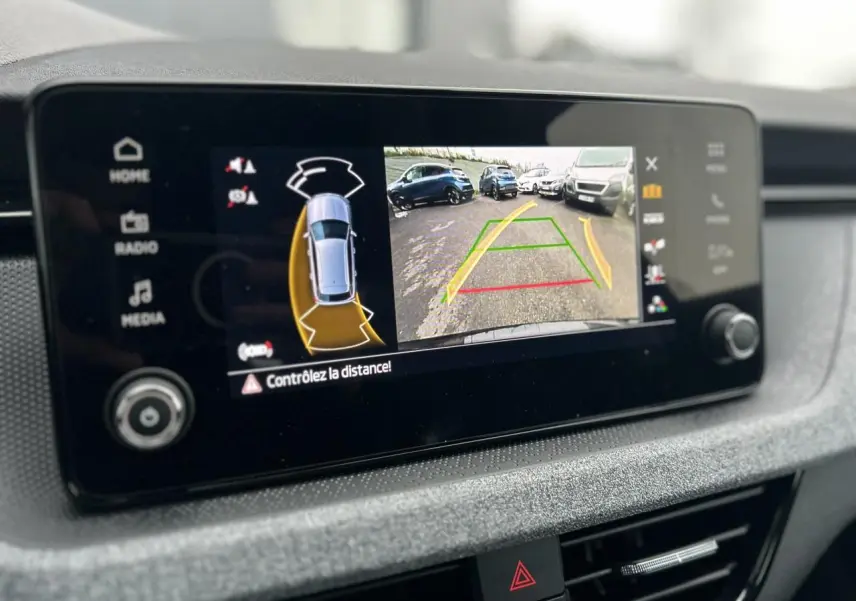 Écran central du Skoda Kamiq noir Magic montrant la caméra de recul avec guidage de trajectoire et alertes de proximité.