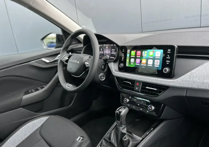 Vue intérieure côté conducteur du Skoda Kamiq 2025 noir Magic, avec écran tactile Apple Car Play et volant multifonctions cuir.