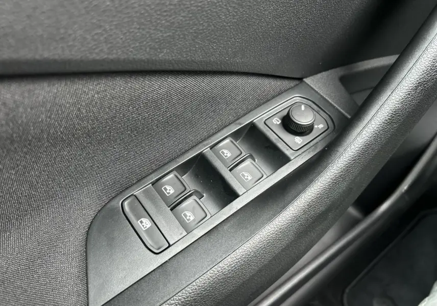 Gros plan sur les commandes de lève-vitres et rétroviseurs côté conducteur du Skoda Kamiq noir Magic 2025.