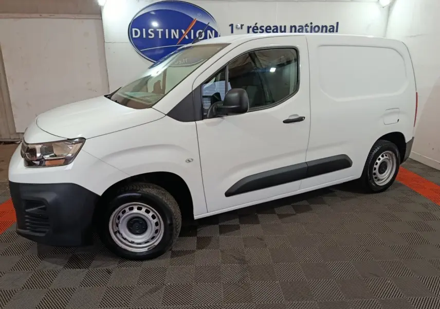 Vue de profil côté gauche d'un utilitaire Citroën Berlingo blanc avec jantes acier et protections noires sur les portes.