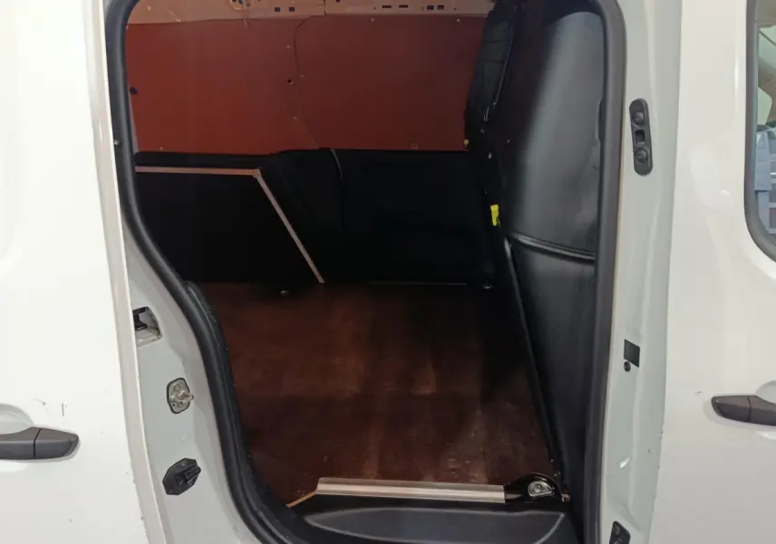 Vue intérieure de la zone de chargement du Citroën Berlingo blanc avec cloison pleine et plancher en bois.
