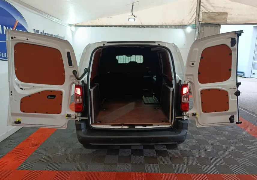 Vue arrière du Citroën Berlingo blanc 2021 avec portes ouvertes dévoilant l'espace de chargement vide et cloison pleine.