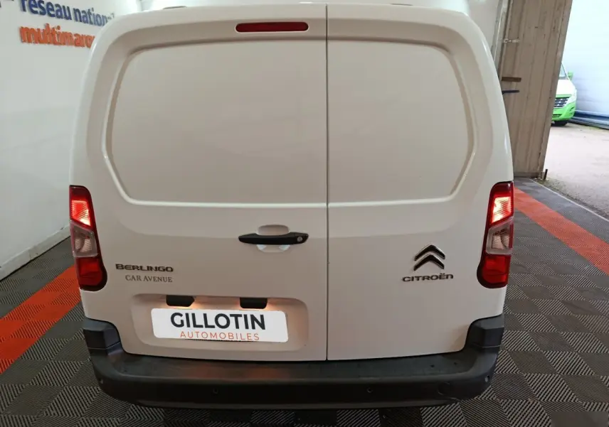 Vue arrière du Citroën Berlingo blanc 2021 avec portes battantes et feux arrière allumés dans un garage.