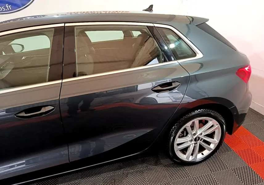 Vue latérale droite d'une Audi A3 gris foncé 2021, mettant en valeur la porte arrière et la jante alliage.