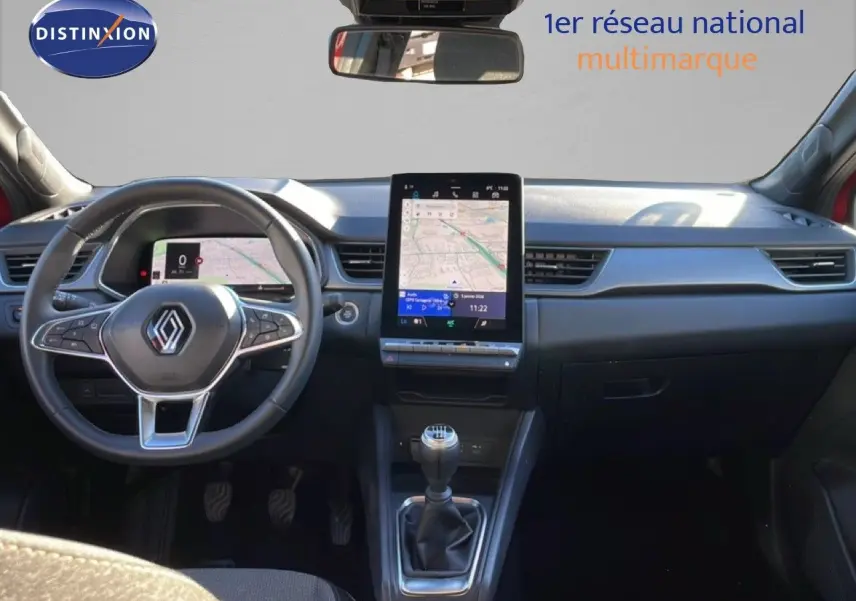 Vue intérieure frontale du tableau de bord du Renault Captur rouge Désir Métal avec écran tactile vertical et volant multifonction.