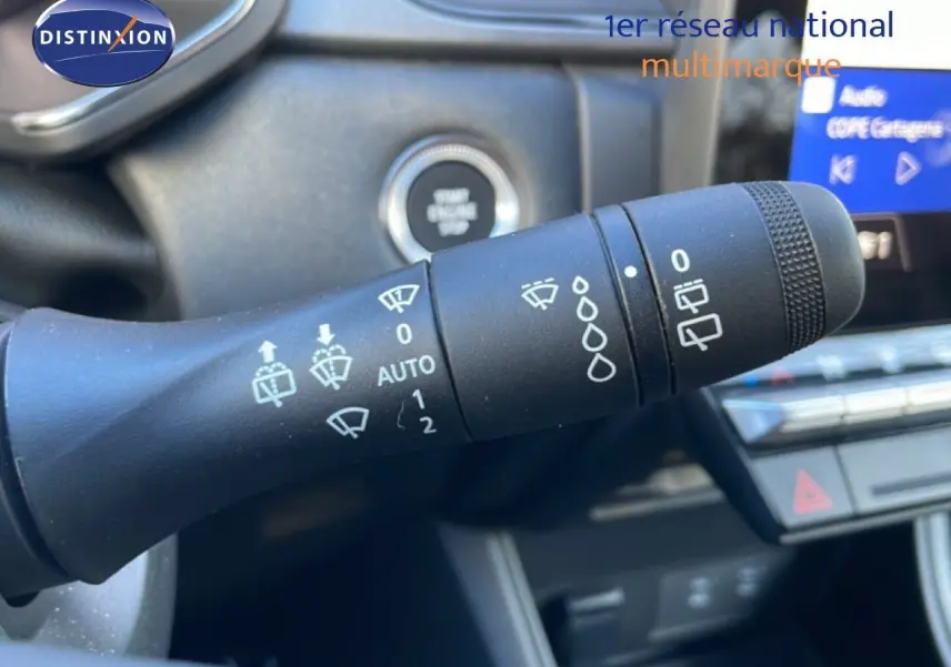 Gros plan sur la commande d'essuie-glace du Renault Captur 2025, intérieur noir avec bouton start/stop visible.