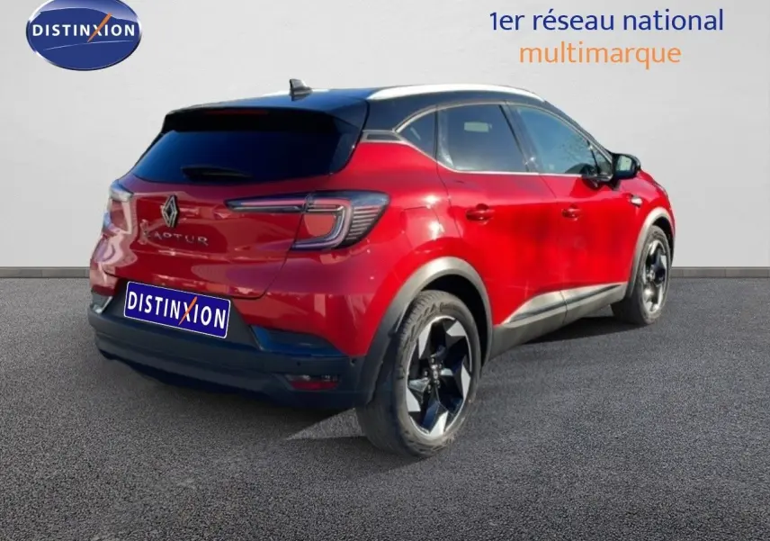 Vue 3/4 arrière droite d'un Renault Captur rouge Désir métal avec toit noir et jantes noires brillantes.