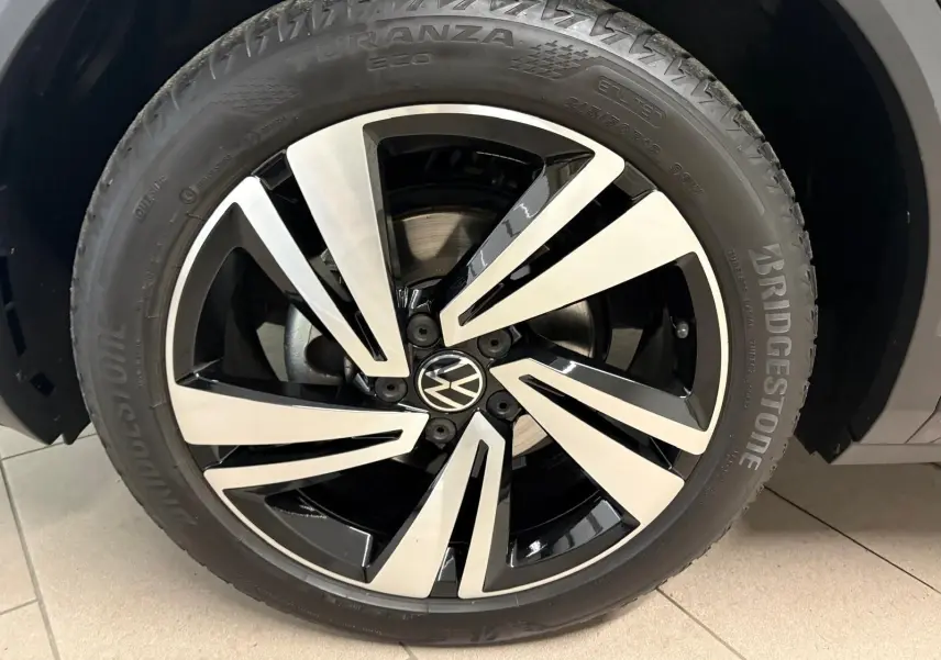 Gros plan sur la jante alliage bicolore noir et argent du Volkswagen T-Roc 1.5 TSI 150 DSG7 R-Line Edition noir intense.