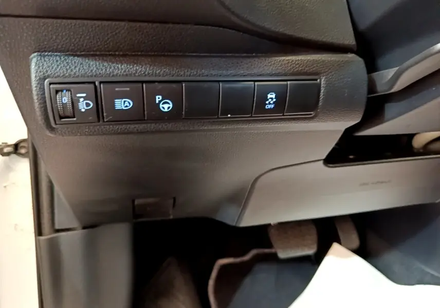 Vue intérieure côté conducteur de la Toyota Corolla hybride blanche 2022, panneau de commandes des aides à la conduite.