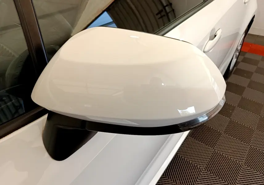 Gros plan sur le rétroviseur droit blanc de la Toyota Corolla hybride 2022, avec clignotant intégré.