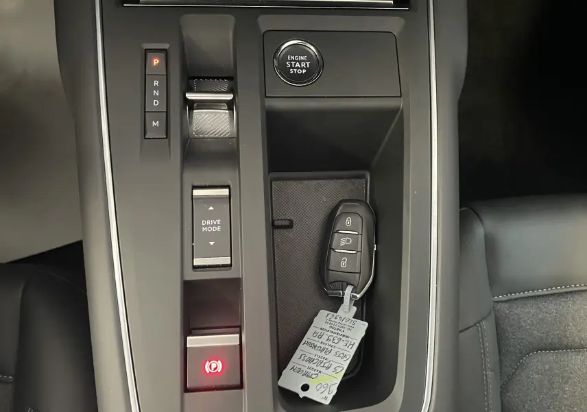 Vue rapprochée de la console centrale du Citroën C5 Aircross hybride 2025, avec clé et bouton start/stop visibles.