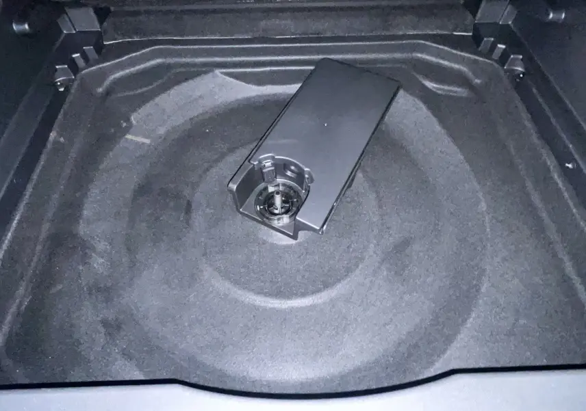 Coffre ouvert vu de dessus d'une Citroën C5 Aircross hybride gris platinium, montrant le rangement sous plancher.