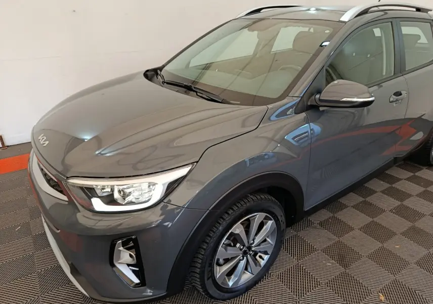 Vue 3/4 avant droite du KIA STONIC 1.0 T-GDI 100 Urban gris foncé avec phares ellipsoïdaux et jantes alliage.