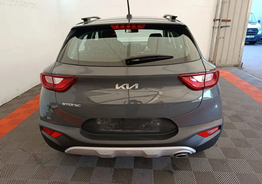Vue arrière d'un KIA Stonic gris foncé 2023, mettant en valeur ses feux arrière distinctifs et son logo central.