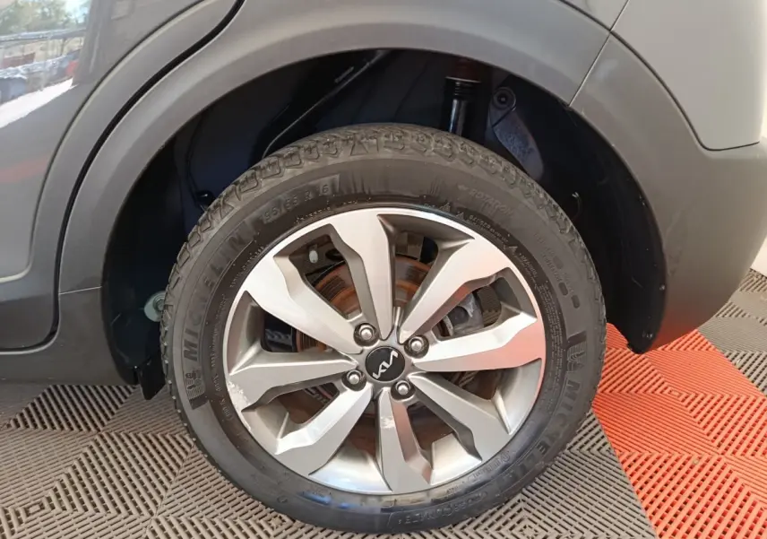 Gros plan sur la roue avant droite d’un KIA STONIC gris foncé, avec jante alliage et pneu Michelin visible.