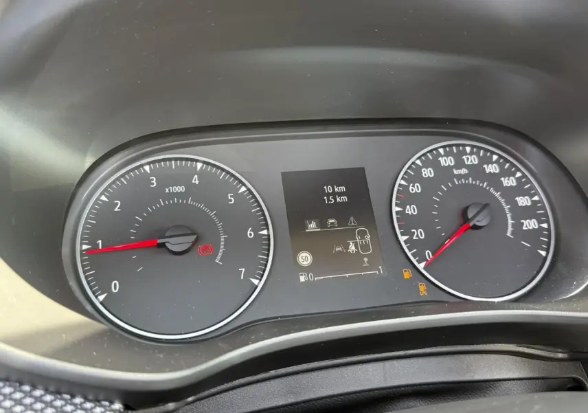 Vue rapprochée du tableau de bord numérique de la Dacia Sandero Stepway 2025 avec compteurs analogiques et indicateurs lumineux.