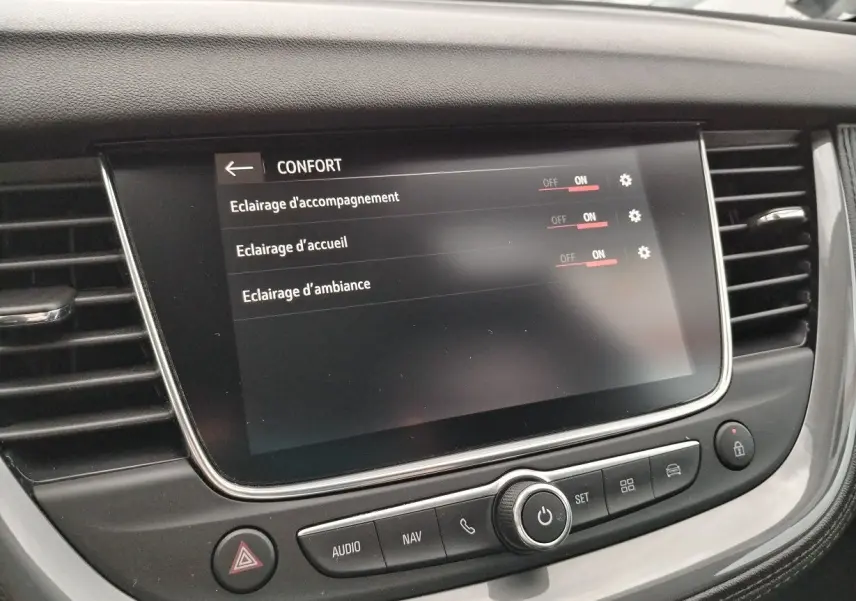 Écran tactile central de l'Opel Grandland X 2019 affichant les réglages d'éclairage confort, entouré de commandes noires.