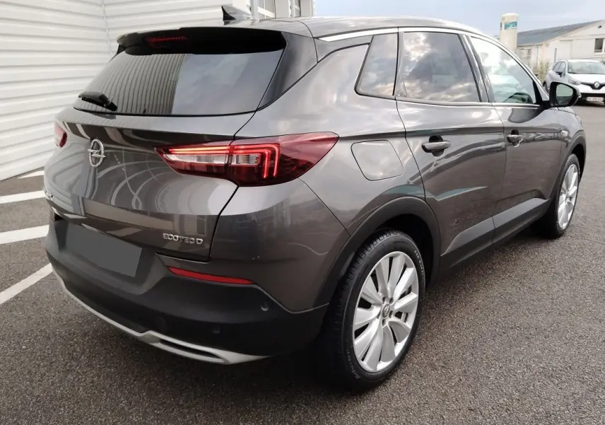 Vue 3/4 arrière droite d'un Opel Grandland X gris platinium avec feux LED et jantes alliage.