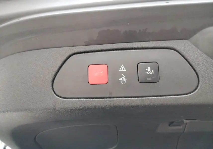 Boutons rouge et noir pour ouverture et verrouillage du coffre sur le hayon intérieur d'un Opel Grandland X gris platinium.