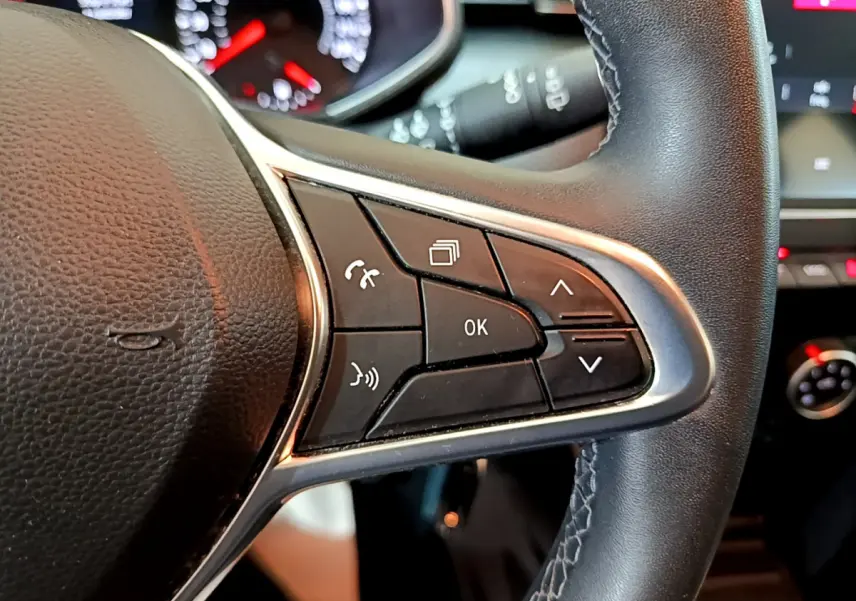 Gros plan sur les commandes multifonctions du volant cuir noir de la Renault Clio Business Blue dCi 85 de 2020.