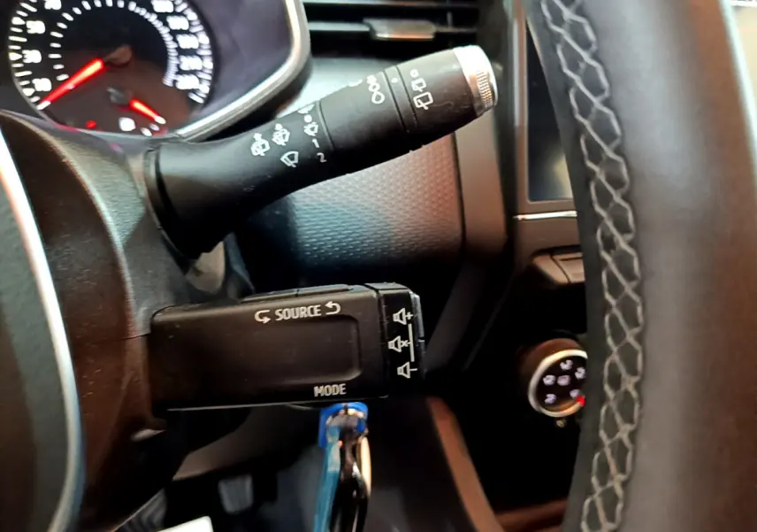 Gros plan sur la manette multifonction gauche et volant cuir noir de la Renault Clio Business Blue dCi 85 2020.