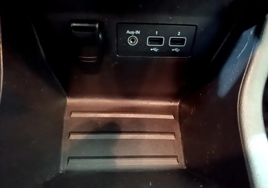 Gros plan sur la console centrale noire de la Renault Clio Business Blue dCi 85, montrant ports USB et prise Aux-In.