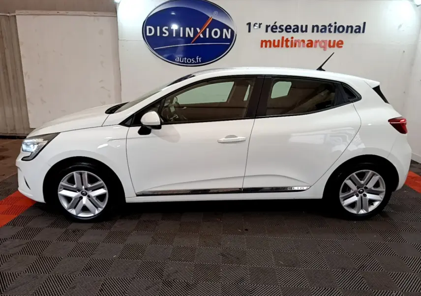 Profil côté gauche d'une Renault Clio Business Blue dCi 85 blanche, avec jantes alliage et poignées de porte assorties.