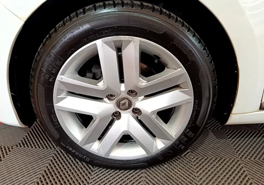 Gros plan sur la roue avant droite d'une Renault Clio Business Blue dCi 85 blanche, avec jante et pneu visibles.