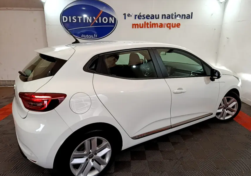 Vue côté droit arrière d'une Renault Clio Business Blue dCi 85 blanche avec jantes alliage et feux arrière LED allumés.