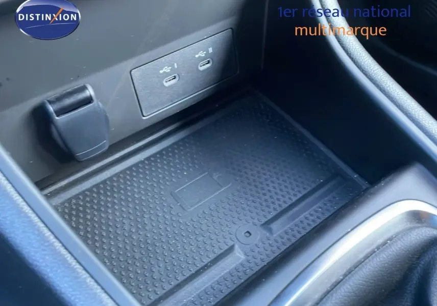 Gros plan sur la console centrale noire du Renault Captur 2025, avec ports USB-C et espace de rangement antidérapant.