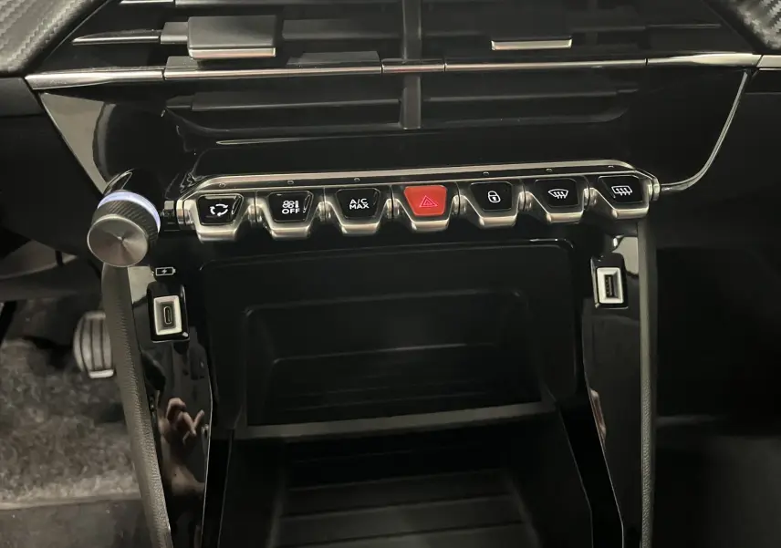 Vue rapprochée de la console centrale noire brillante du Peugeot 2008 Active Business 2020 avec boutons de commande alignés.