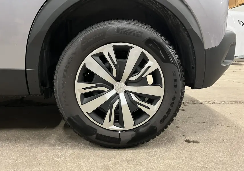 Gros plan sur la roue avant droite du Peugeot 2008 gris alu, mettant en valeur la jante et le pneu hiver Pirelli.