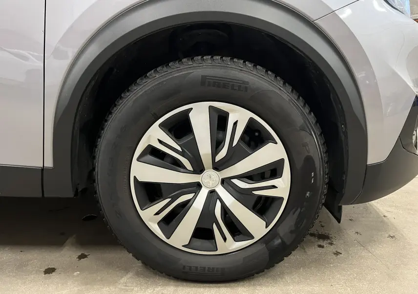 Gros plan sur la roue avant gauche d’un Peugeot 2008 gris alu, avec jante alliage au design moderne et pneu Pirelli.